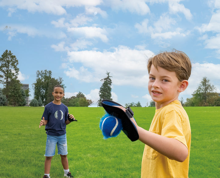 Two boys playing Toss & Catch Ball Game outdoors on green grass under blue sky with scattered clouds