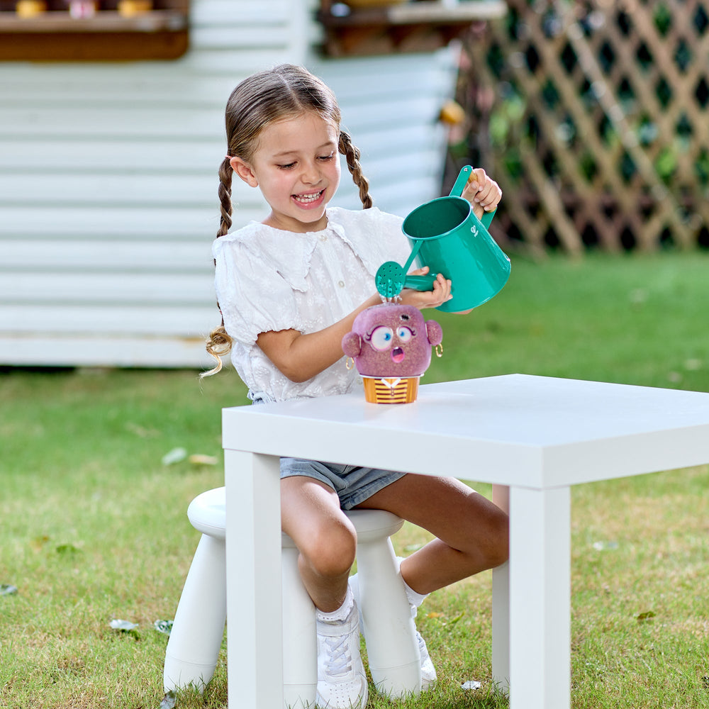 Young girl playing with a plant pal watering outdoors