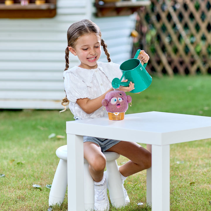 Young girl playing with a plant pal watering outdoors